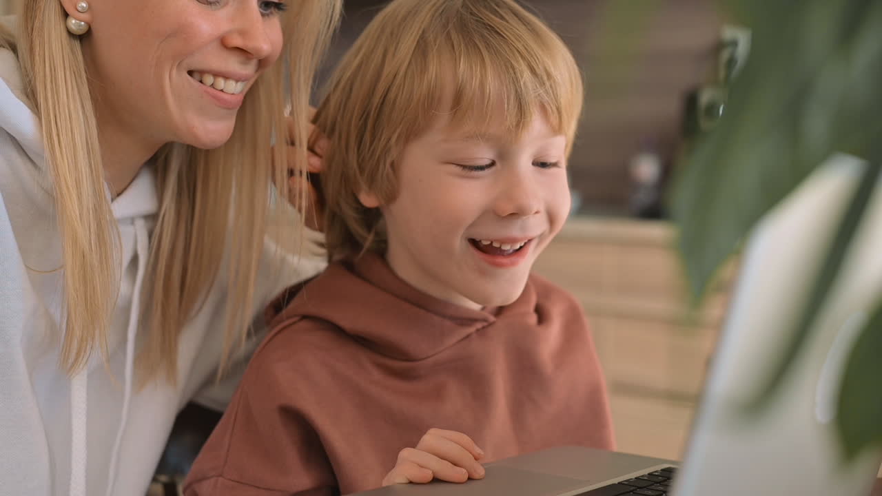 маленький мальчик и мама используют ноутбук и развлекаются дома
