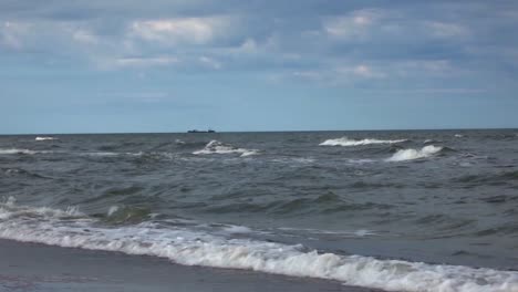 the sea waves shore and a large ship at sea