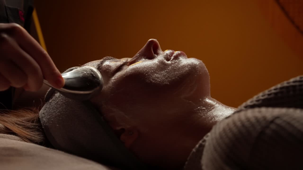 Kvinde får afslappende ansigtsbehandling på et spa