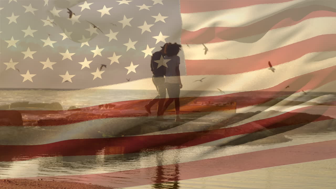animación de la bandera de los estados unidos sobre una pareja afroamericana en la playa
