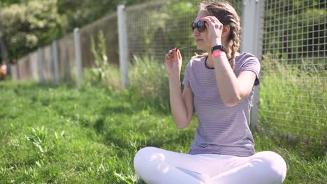 portrait of an attractive smiling caucasian woman in a park with glasses