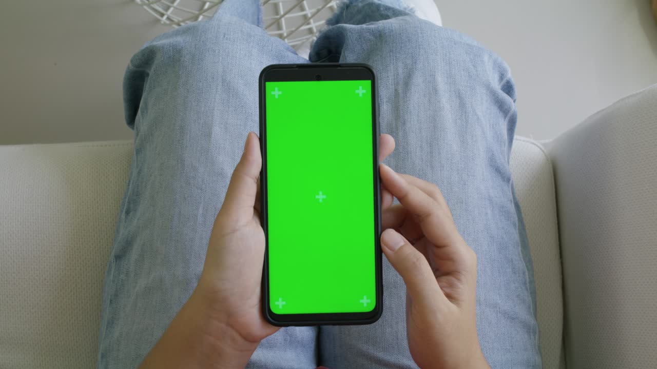 Woman holding chroma key green screen smartphone watching content