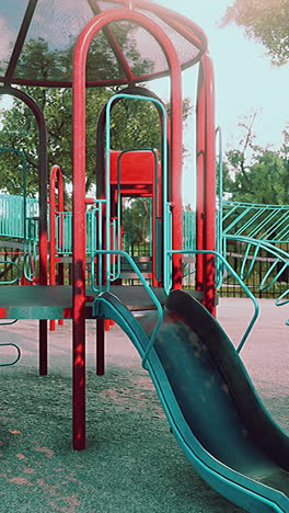 un tobogán de patio de recreo rojo y azul con una estructura metálica