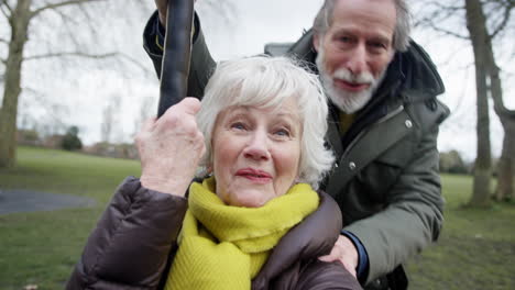 Senior-Couple-Having-Fun-Playing-On-Zip-Wire-In-Park-Playground