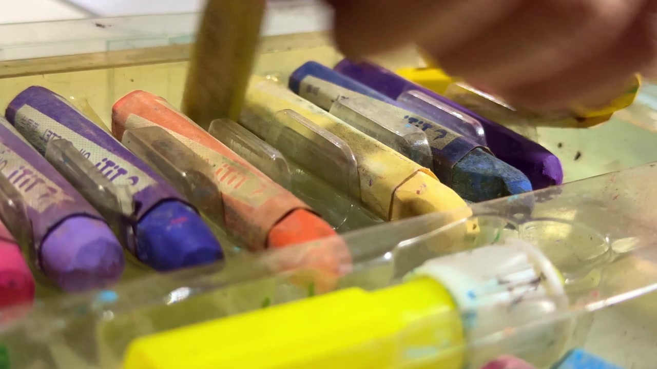 Mano eligiendo un crayón colorido de una caja, primer plano de materiales de arte, concepto de creatividad infantil y preparación para el dibujo