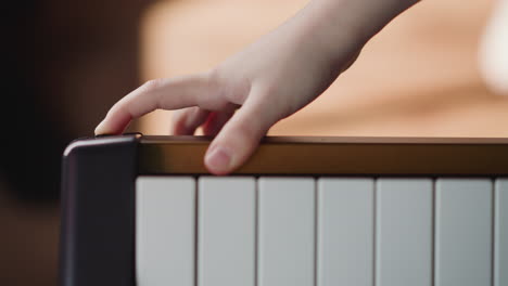 hand turns on electronic piano and starts playing melody