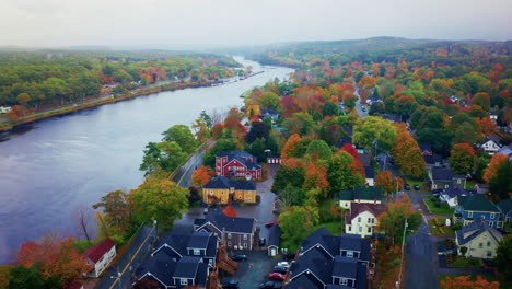 aerial drone shot over a local town next to a river in nova scotia, canada.
bird's eye view over the autumn landscape. colorful trees foliage.