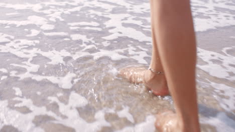 Walking,-water-and-feet-of-a-woman-at-the-beach