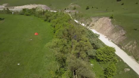 vista aérea de un prado verde abierto con una pequeña carpa naranja