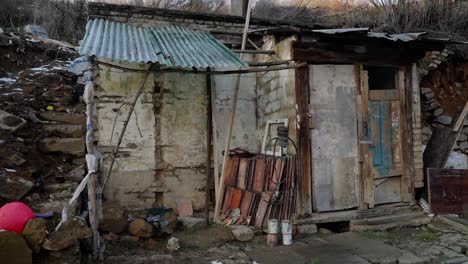 improvised and damaged shed in a snowy rural setting with tools and materials scattered nearby