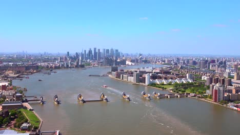 Vista-Aérea-De-La-Barrera-Del-Támesis-Con-Canary-Wharf-Y-La-Ciudad-De-Londres-Detrás