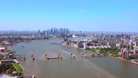 aerial view of the thames barrier with canary wharf and the city of london behind