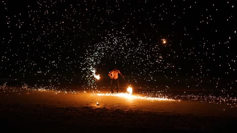 performer displays fire skills on sandy beach