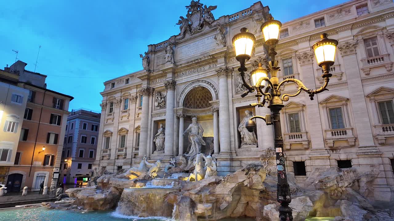 Trevi Fountain early in the morning dawn before sunrise, ornate lamp illuminating facade, Rome, Italy