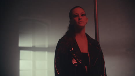 woman in leather coat in a dark room