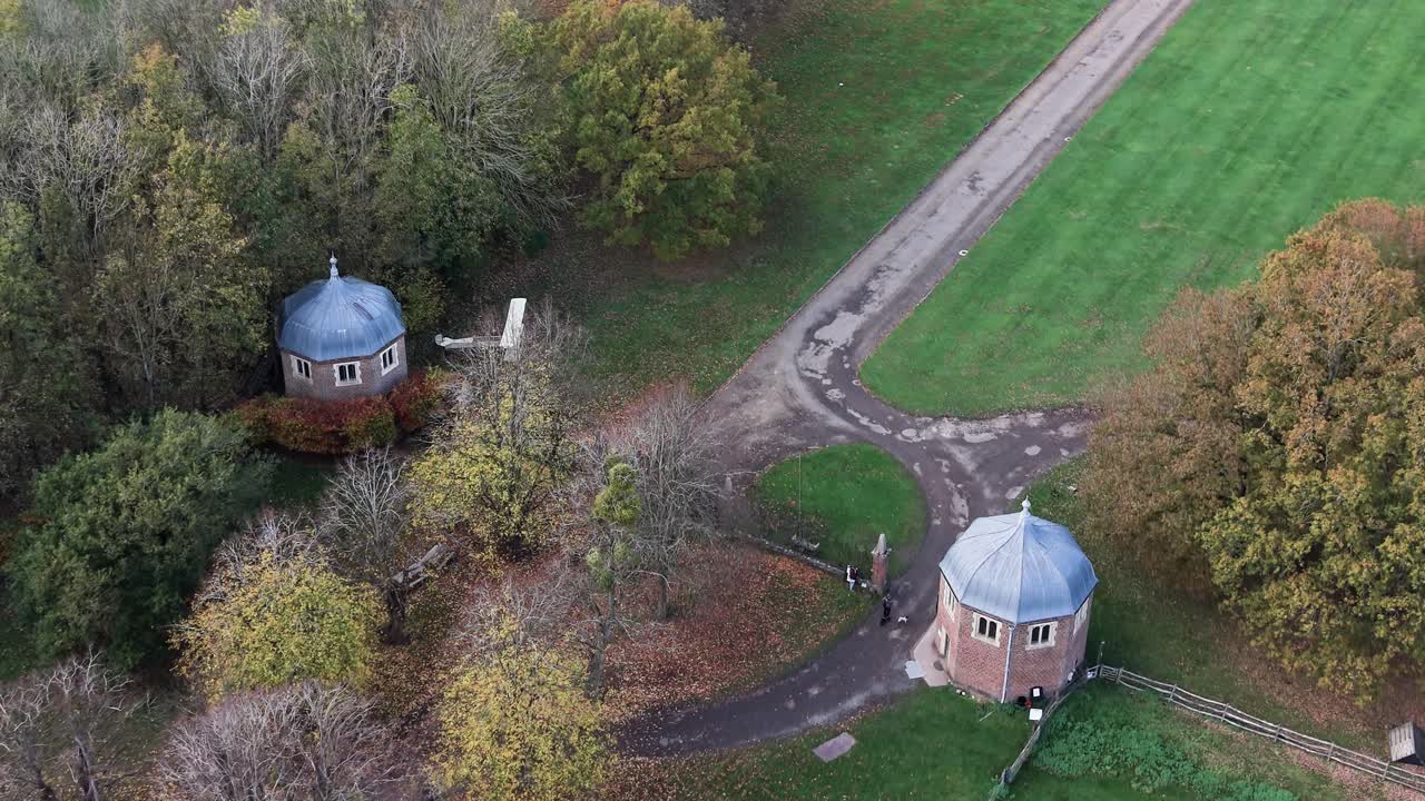 Kentwell hall aerial view looking down over Tudor estate domed gate houses and Autumn parkland path