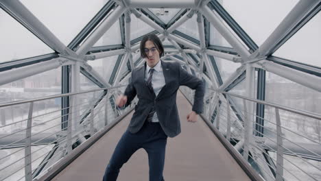 businessman dancing on a modern city bridge