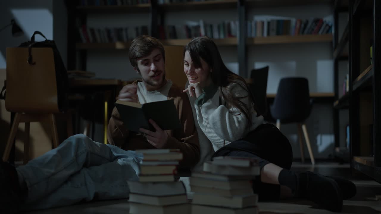 estudiantes felices leyendo juntos en una biblioteca