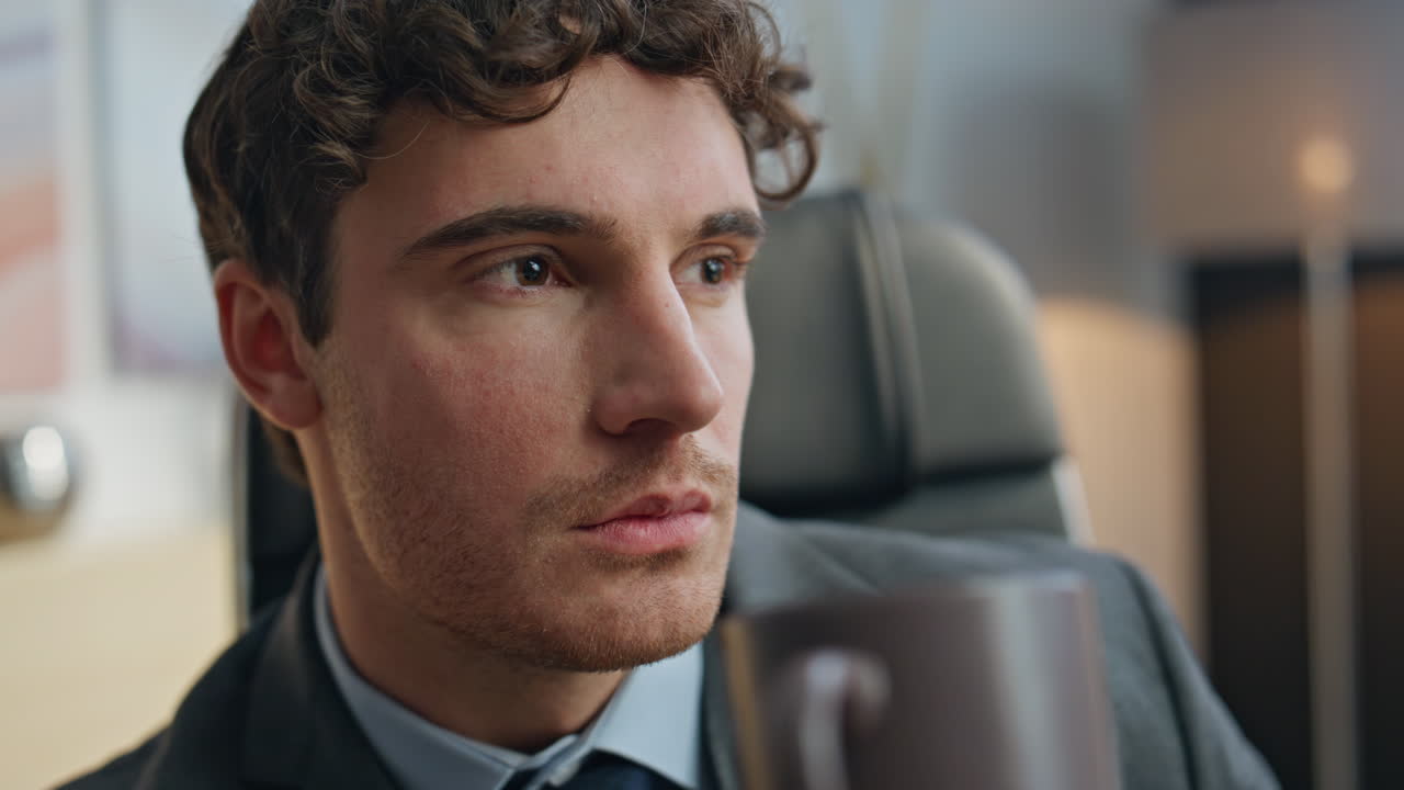 Thoughtful businessman drinking tea at office closeup. Manager thinking future