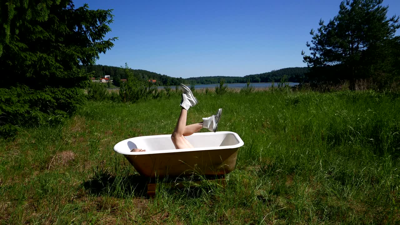 호수 에 욕조가 있고 그 안에 한 소녀가 있습니다.