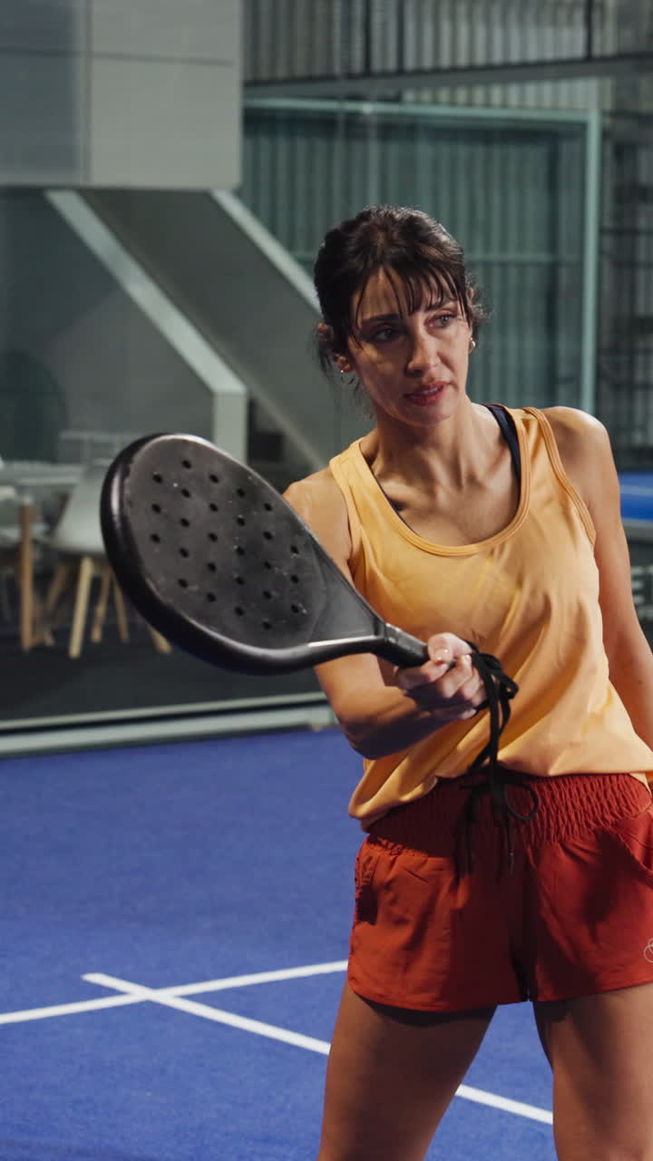 Woman Practicing Padel on an Indoor Court with a Coach