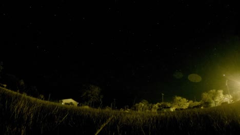 lapso de noche - estrellas en el cielo sobre un campo en medio de la noche en un pequeño pueblo en emperatriz alberta canadá