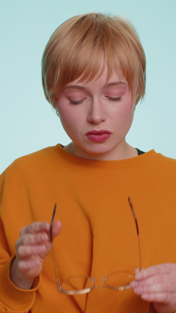 Una donna esausta e stanca si toglie gli occhiali, sente dolore agli occhi, è sovraccarica di lavoro, esaurimento, mal di testa al lavoro.