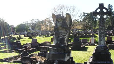 dron volando alrededor de una estatua de ángel de piedra en un cementerio de cementerio en un día muy soleado