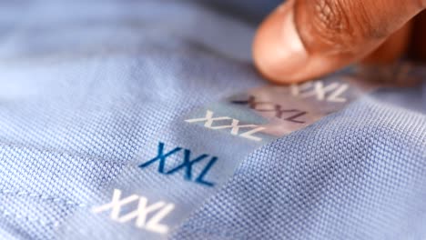 close-up of a size tag on a blue shirt, showing xxl size