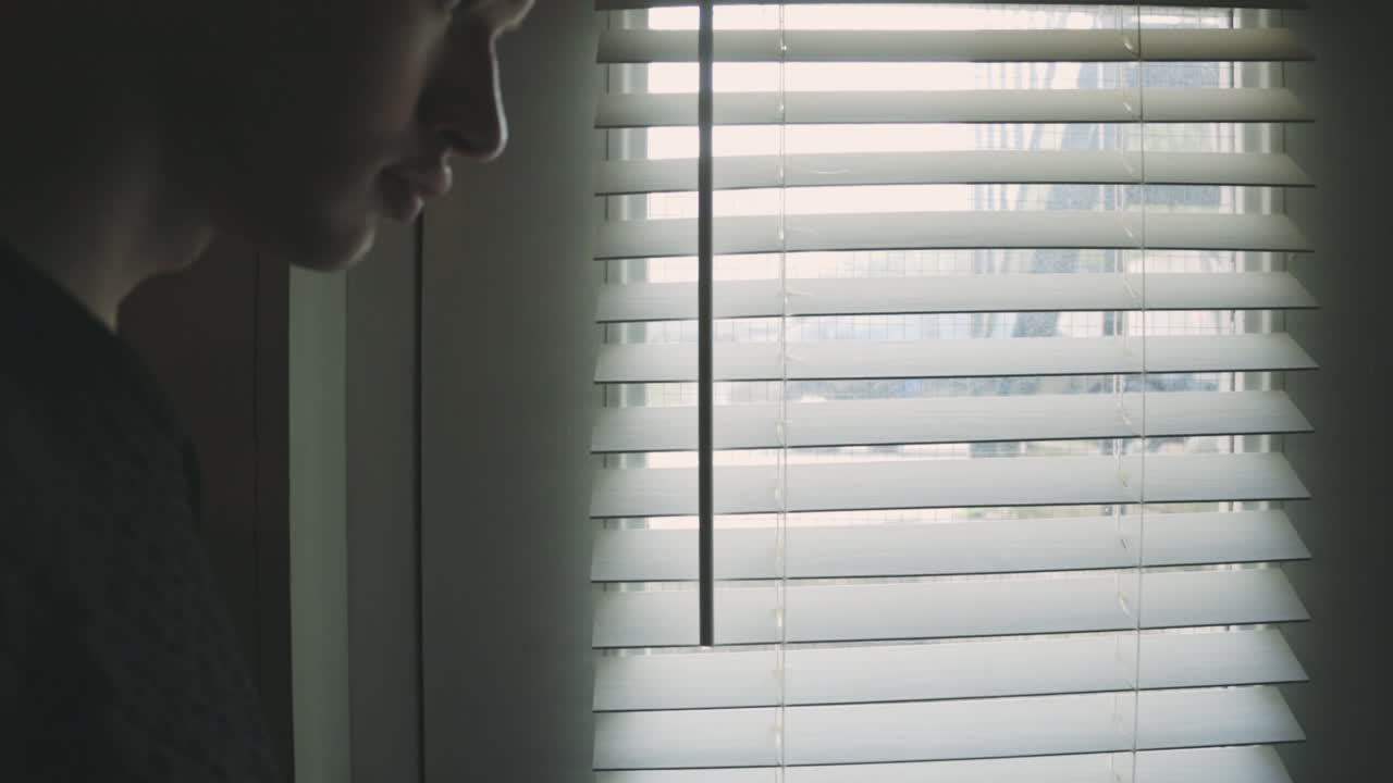Back Of A Man Looking Out From The Window Of His Room - Closeup Shot