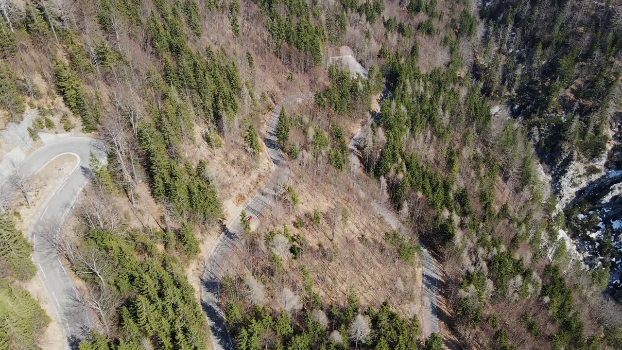 Aerial View of a Winding Mountain Road through a Forest