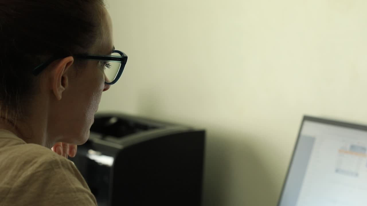 Female office worker concentrating on her PC monitor