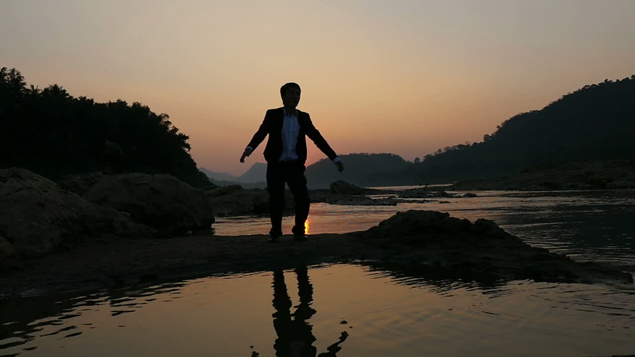 Man Celebrating Sunset by the River