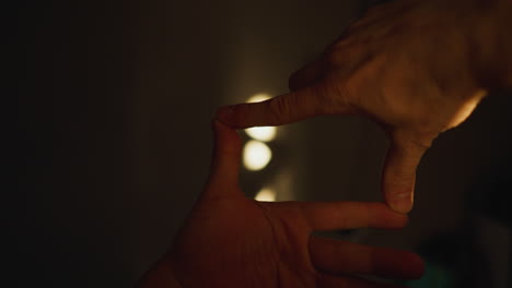 pov of hands forming a cinematic frame, capturing shadows on the wall through sunlight, shot with a hand-held camera