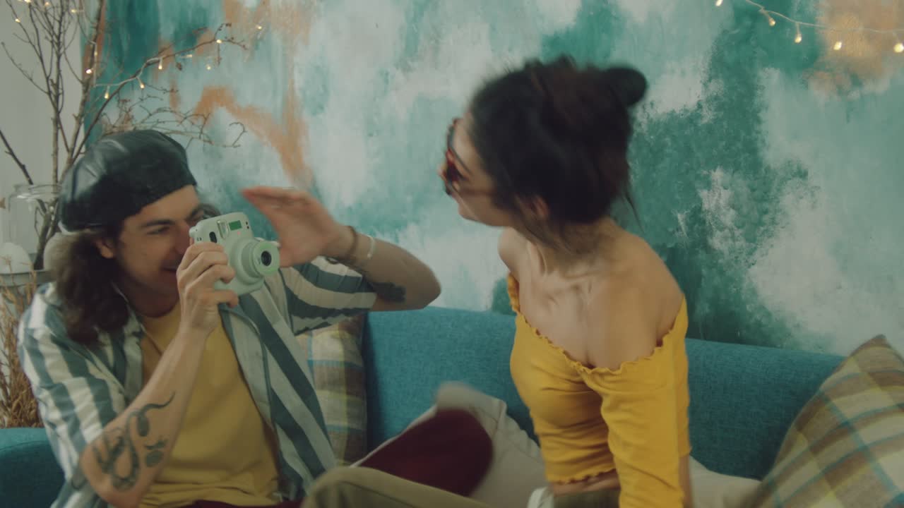 Couple Taking Polaroid Photo at Home