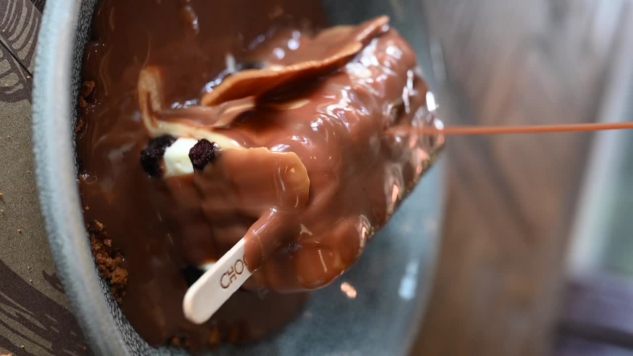 수직 영상: 초콜릿과 아이스크림의 조합인 베이비 다이너마이트 디저트에 카라멜 소스를 부어 넣는 것