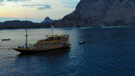 Ein-Kreuzfahrtschiff-Ankerte-Vor-Der-Küste-Der-Insel-Padar,-In-Der-Nähe-Von-Komodo-In-Indonesien,-Aufgenommen-Von-Einer-Drohne-Am-Abend