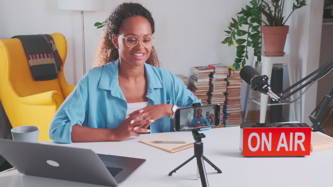 Young confident charismatic african american woman films video blog on phone