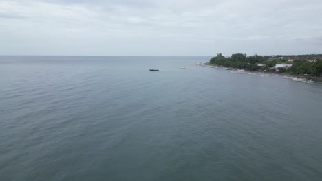 Coastal-views-on-a-cloudy-morning-in-Lovina,-North-Bali,-moving-toward-a-boat-out-at-sea