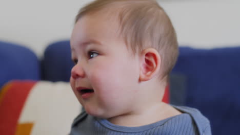 Baby-boy-smiling-at-rainbow-colored-silk-ribbons