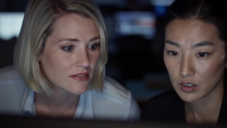 intense focus and collaboration: two professionals engaged in critical work amid dim lighting and technology, demonstrating teamwork and concentration