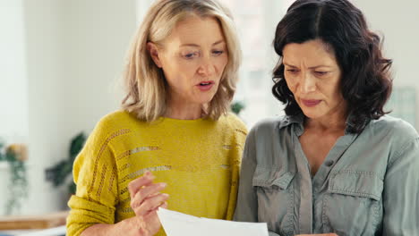 Same-Sex-Mature-Female-Couple-At-Home-Checking-Domestic-Bills-Worried-About-Personal-Finances