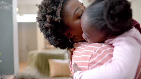 african american mother and daughter hugging at home, slow motion