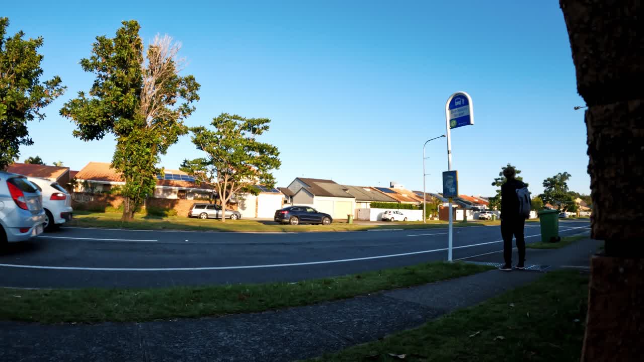 hombre caminando por la acera y esperando en una parada de autobús