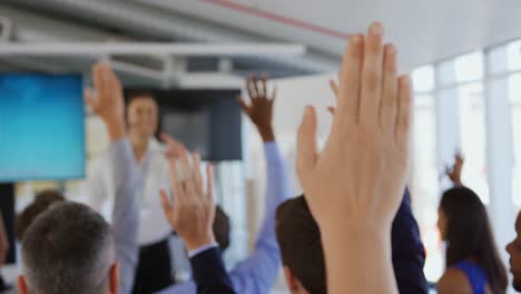 businessman inviting questions from the audience at a business presentation