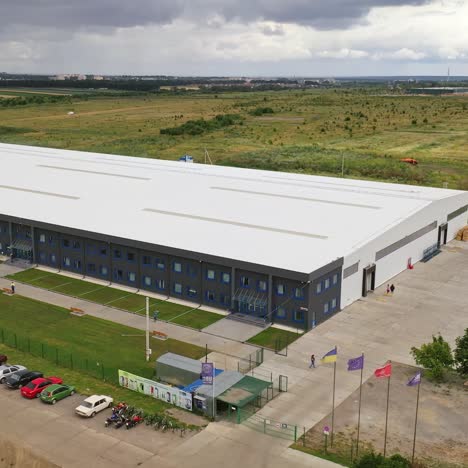 modern industrial exterior. large factory building among green fields. new building from outdoors. aerial view.