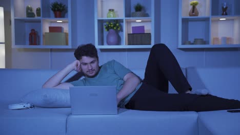 man looking at laptop in surprise at night at home. surprised by what he saw on the laptop.