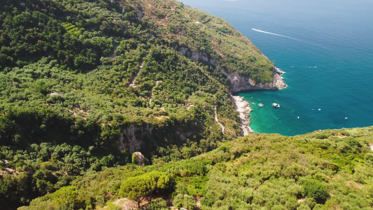 Aerial - Lush Punta Campanella coastline showing idyllic beach, Tyrrhenian Sea, Italy