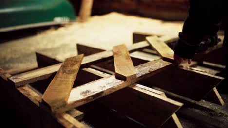 a man is driving nails into the sawbuck using a drill in indre fosen, trondelag county, norway - close up