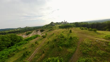 Fast-motion-FPV-drone-aerial-shot-of-Olsztyn-castle,-trail-of-the-eagle-nest-in-Jura-Krakowsko-Częstochowska,-Poland